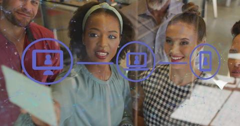 Diverse team collaborating at glass wall reviewing digital flowchart and brainstorming ideas