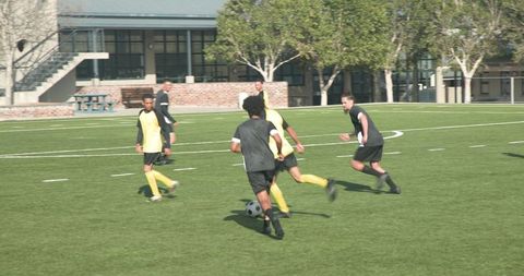 Soccer players competing on field in team strategy