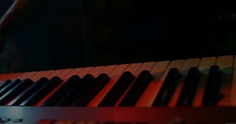 Electronic keyboard illuminated by stage lights in studio