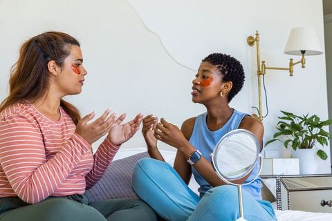 Multiracial friends enjoying at-home skincare routine with gel eye patches and relaxed chat