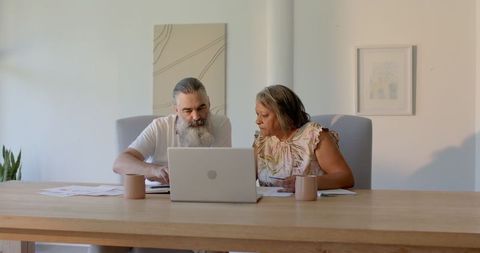Senior Couple Discussing Finances with Laptop at Home