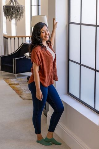 Smiling woman standing by frosted window in cozy modern living room