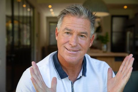Friendly Middle-Aged Man Gesturing in Modern Home Kitchen