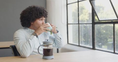 Young professional enjoys coffee break in modern office