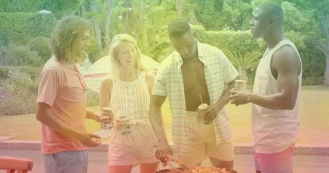Friends grilling by poolside holding drinks at summer backyard cookout