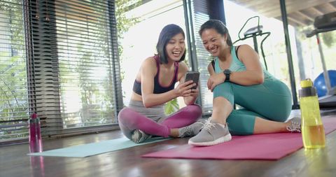 Happy Friends Using Smartphone in Home Gym