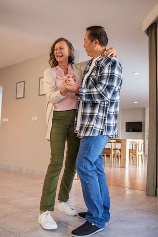 Joyful Mature Couple Dancing in Modern Living Space