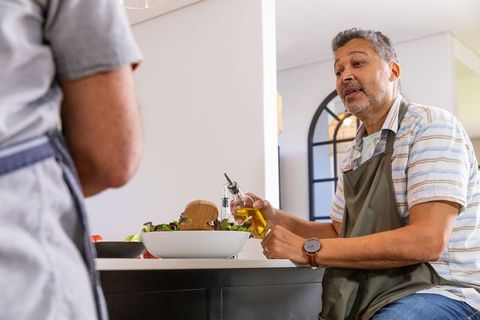 Senior Couple Preparing Fresh Salad Together in Modern Kitchen