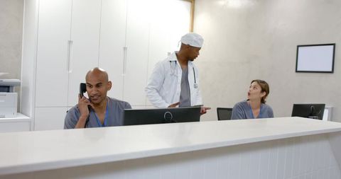 Diverse medical reception team answering calls and coordinating patient care in clinic