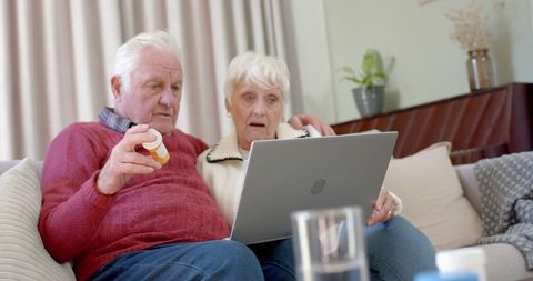 Senior Couple Consulting Online Doctor with Laptop at Home