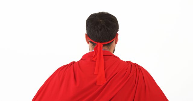 A middle-aged Caucasian man is dressed as a superhero, with a red cape and mask, against a white background, with copy space. His pose suggests readiness to tackle challenges, embodying the classic superhero persona.