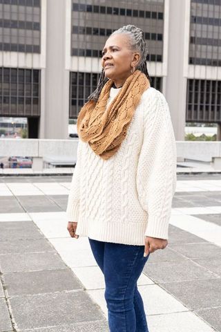 Mature african american woman standing on rooftop wearing cable-knit sweater infinity scarf