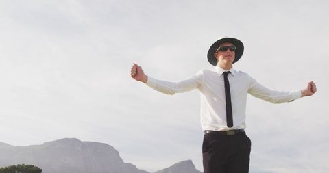 Cricket Umpire Making Signals on Field with Mountain Background
