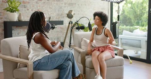 African american women recording casual podcast conversation in cozy home studio