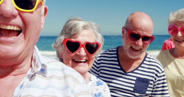 Joyful Seniors Wearing Heart-shaped Sunglasses Having Fun at Beach - Download Free Stock Images Pikwizard.com