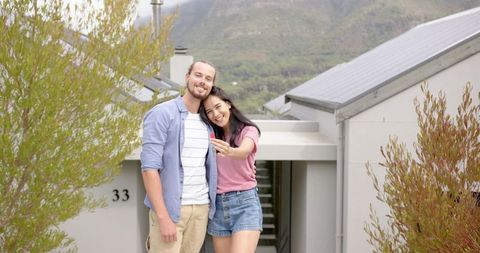 Excited couple celebrating new home ownership outdoors
