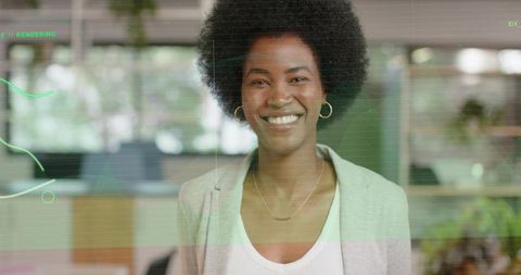 Smiling professional woman wearing blazer and gold hoops in modern open-plan office with green overl