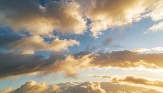 Golden Layered Clouds Bathing Horizon at Sunset with Blue Sky Peeking Through