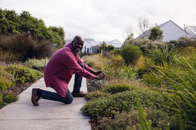 Image of happy african american man in garden. Lifestyle, spending free time at home and garden concept.