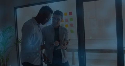 Coworkers in business attire collaborating with tablet