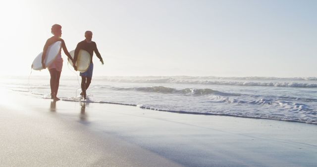 Couple Walking Along Beach with Surfboards at Sunrise - Download Free Stock Photos Pikwizard.com