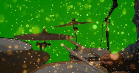 Dynamic drummer playing in green chroma key studio