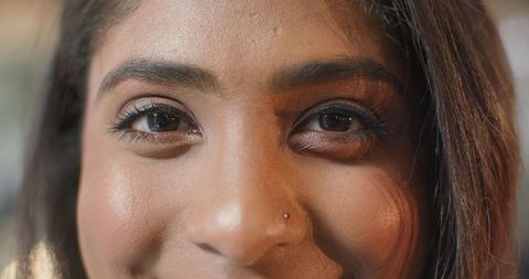 Closeup indian woman wearing nose stud and eyeliner holding steady gaze