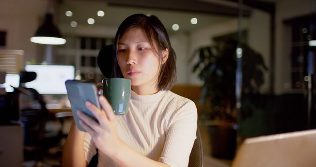 Focused Woman Working Late Night in Office, Using Smartphone and Drinking Coffee - Download Free Stock Images Pikwizard.com