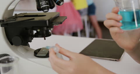 Young Student Conducting Science Experiment with Microscope