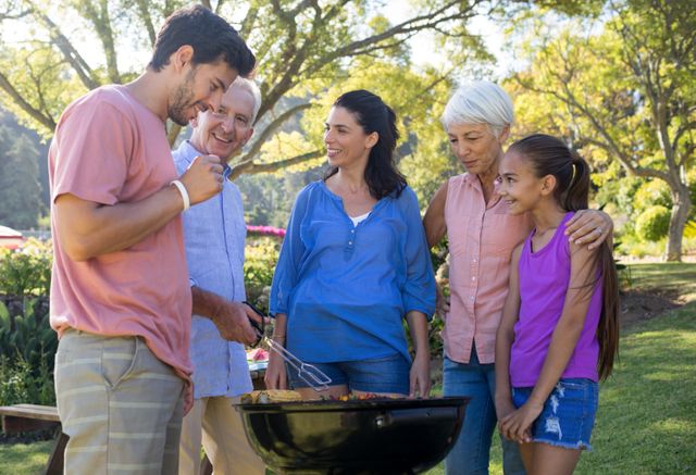 Happy family preparing barbecue in the park