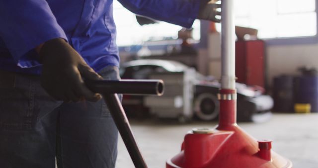 Female mechanic placing oil changing equipment under the car at a car service station. automobile repair service