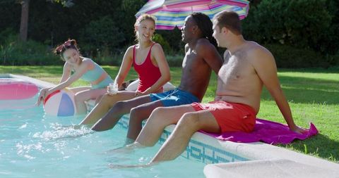 Friends enjoying summertime at poolside with beach ball