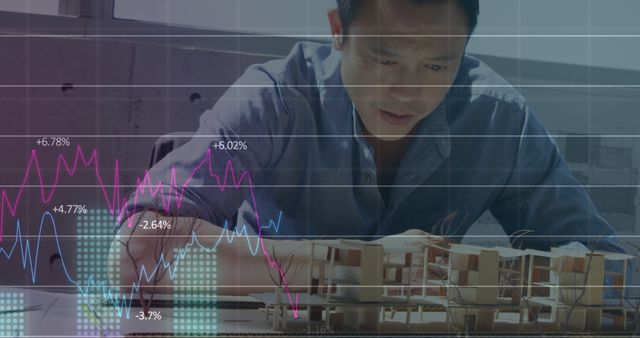 Architect analyzing architectural model with a financial graph overlay. Useful for illustrating themes of business analysis, planning in architecture, financial modeling in construction, and market trend monitoring in engineering projects.