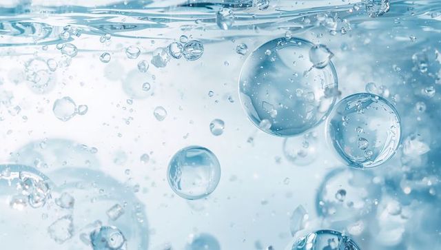 Floating Clear Water Bubbles Beneath Liquid Surface with Light Reflections and Soft Blue Tones