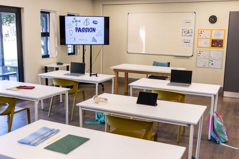 Empty modern classroom with laptops, tablets and passion display for remote learning