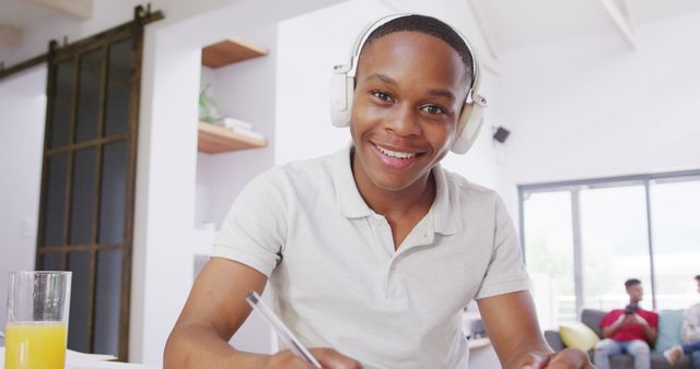 Smiling African American Teen Enjoying Homework at Home Wearing Headphones - Download Free Stock Images Pikwizard.com