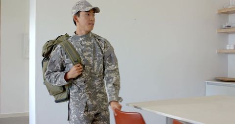 Asian Male Soldier Entering Room in Uniform, Ready for Action