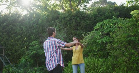 Couple Joyfully Dancing Amidst Lush Green Garden