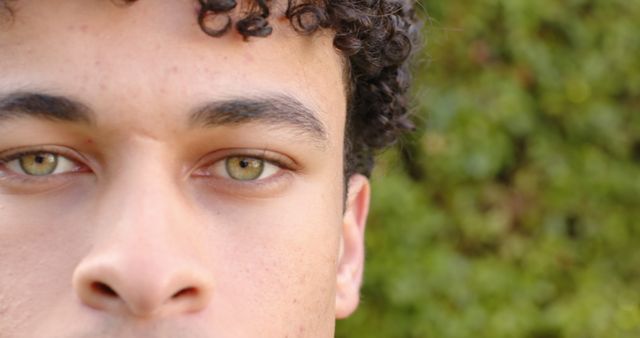 Close-Up of Young Man with Curly Hair and Green Eyes Outdoors - Download Free Stock Images Pikwizard.com