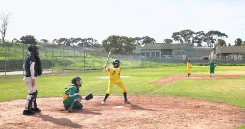 Girls baseball game on community park field demonstrating athletics