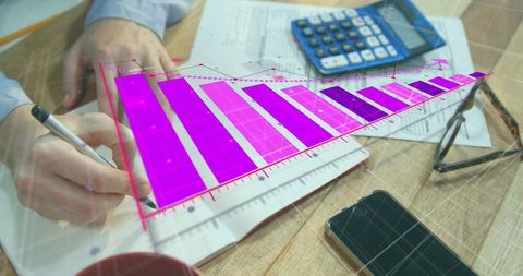 Hands writing financial notes with calculator and digital magenta bar chart overlay
