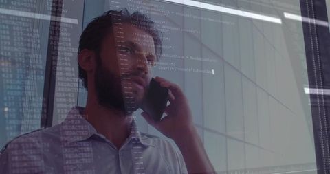 Businessman talking on phone with software code overlay by glass wall in modern urban corporate offi