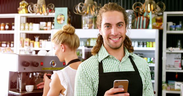 Smiling Barista in a Café Holding a Smartphone - Download Free Stock Images Pikwizard.com