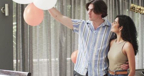 Happy Couple Preparing for Birthday with Balloons