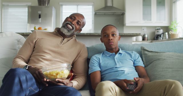 Father and Son Relaxing on Couch Watching TV at Home - Download Free Stock Images Pikwizard.com