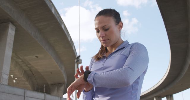 Female Athlete Checking Smartwatch under Urban Overpass - Download Free Stock Images Pikwizard.com