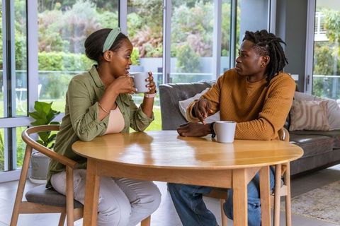 African american couple sharing morning coffee and conversation at round wooden table