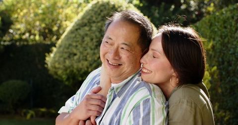 Senior Couple Enjoying Warm Embrace in Sunlit Garden