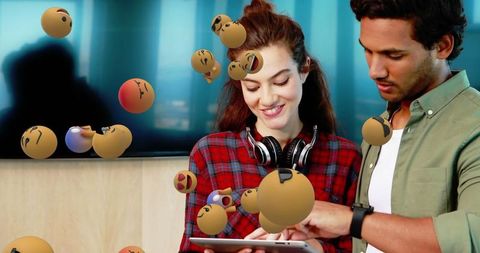 Young professionals collaborating with digital emojis in modern office