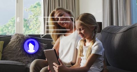 Grandmother and Granddaughter Engaged with Tablet at Home